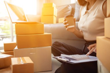 Küçük bir girişimci, gelen siparişleri müşterilere ulaştırmak üzere nakliye şirketine götürmek üzere ürünleri paket kutularına koyuyor. Concept Etrade Team çevrimiçi satışları
