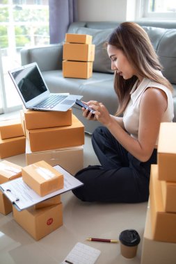 Küçük bir girişimci, gelen siparişleri müşterilere ulaştırmak üzere nakliye şirketine götürmek üzere ürünleri paket kutularına koyuyor. Concept Etrade Team çevrimiçi satışları