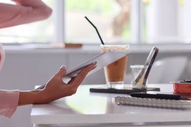 Genç Asyalı iş kadını internet üzerinden yatırım belgeleri toplamak ve organize etmek için dizüstü bilgisayar ve dizüstü bilgisayar kullanıyor. Genç iş kadını kavramı yatırım yapmak için teknolojiyi kullanıyor