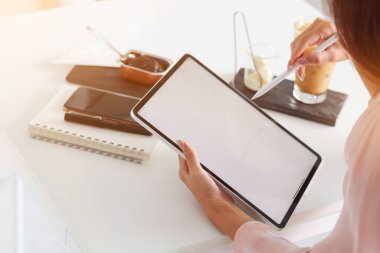 Genç Asyalı iş kadını internet üzerinden yatırım belgeleri toplamak ve organize etmek için dizüstü bilgisayar ve dizüstü bilgisayar kullanıyor. Genç iş kadını kavramı yatırım yapmak için teknolojiyi kullanıyor