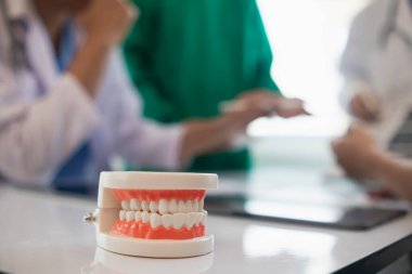 Diş hekimlerinden oluşan bir ekip konferans odasında hasta diş ağrısını tedavi ediyor. Doktorlar ve dişçiler, iltihaplanma nedeniyle ağrıya yol açan kanal tedavisi için bir araya geliyorlar..