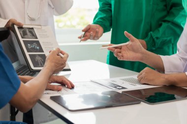 Tıp ekibinin konferans odasında hastalıkları teşhis etme ve tedavi etme yeteneğini harekete geçirme kavramı. Tıbbi ekip toplantıya katılır ve hasta hastalığını doğru şekilde tedavi etmek için tartışır.