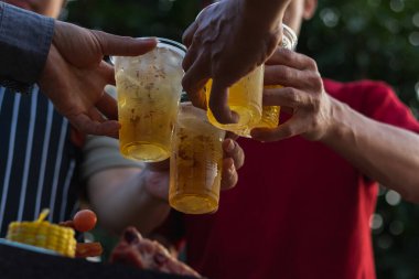 Arkadaşlar arasında barbekü partisi için hazırlanan biralar plastik bardaklarda servis ediliyor, çünkü parti sonunda plastik bardaklar kolayca saklanabiliyor. Plastik bardakta bira servis ederek parti yapmak kolay..