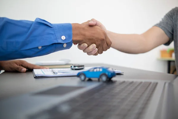 car dealer shook hands with buyer as sign of successful deal and a thank you after the car purchase contract was signed. concept of a handshake to express gratitude after a successful sale contract.