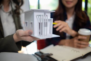 Mimarlar ve mühendisler, inşaatın standartlara uygun ve zamanında tamamlandığından emin olmak için konut inşaatının nasıl tasarlanacağını tartışıyor. Mühendisler ve mimarlardan oluşan bir ekip bina tasarımı ve yapısını tartıştı.