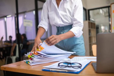 Sekreter toplantıdan hemen önce ofis masasındaki istiflenmiş evrakları karıştırıyor. Yığınla kağıt yığınından satın alma sözleşmesi bulmada konsept sorunu