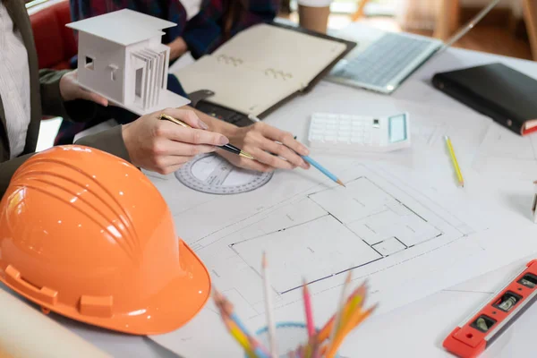 Architects and engineers discuss how to design  housing estate to ensure construction is up to standard and completed on time. team of engineers and architects discuss building design and structure.