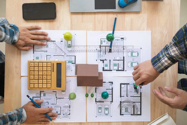建築家やエンジニアは 建築が標準化され 時間通りに完了するように住宅を設計する方法を議論します エンジニアと建築家のチームが設計と構造を議論 — ストック写真