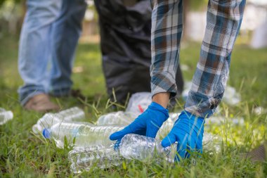 Erkekler çimenliklerden ve parktaki kaldırımlardan plastik şişe toplar ve temiz kalmaları için poşetlere koyar. Geri dönüşüm için plastik şişe de toplayabilirler. Geri dönüşümle çevre sorunlarını azaltmak