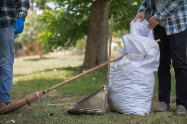 Beyaz çuvallar, gübre yapmak için yaprakları karıştırmak ve parkı temizlemek amacıyla mevsimsel olarak düşen ölü yaprakları içermek için kullanılır. Hindistan cevizi süpürgesi kuru yapraklar için toz kepçesinin yanına oturur..