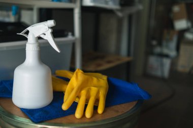 Mavi havlu ve sarı eldivenler, temizlik personelinin deri iltihabını temizlemesi ve önlemesi için ahşap masaya yerleştirildi. Ofisi temizlemek için temizlik şirketini seçme fikri