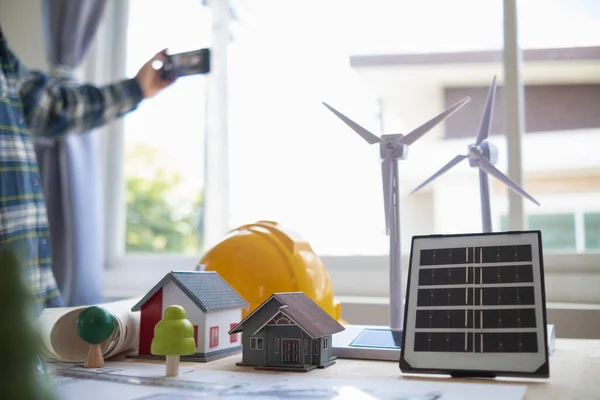 Yenilenebilir enerji mühendislerinden oluşan bir ekip, güneş panellerinin ev desteklerinin yapısını oluşturmak için mimarlarla konuşuyor. Yenilenebilir enerji olarak kullanılacak güneş pilleri kurulumu kavramı