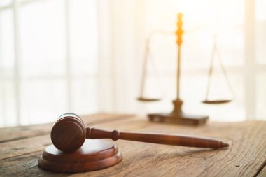 Tahta sehpa üzerindeki tokmak hukuk müşavirliği bünyesinde adaleti temsil eden terazinin bulanık arkaplanı, iyi görünümlü hukuk müşavirliği, yasal tavsiye isteyenleri daha güvenilir kılacaktır..