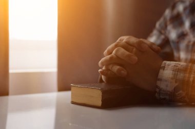 Genç adam, İncil 'in önünde Tanrı' ya inanç ve inançla dua ediyordu. İncil kavramını anlamak ve İncil öğretilerine inanarak Tanrı 'ya dua etmek. Boşluğu Kopyala