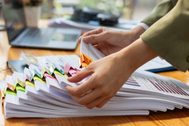 Gayrimenkul alıcılarının mülkiyet kanıtı olarak kullanılabilmesi için yasal bir belge hazırlandı. İstiflenmiş kağıtlar incelenmek üzere masaya kondu..