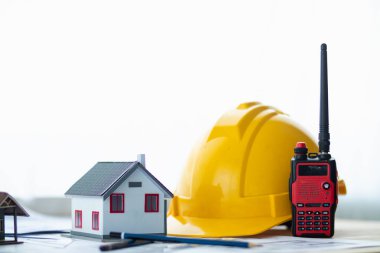 İnşaat mühendislerinin inşaat alanına girmeden önce düşme tehlikesini önlemek için takmaları için sarı başlık hazırlanmıştı. Sarı güvenlik kaskı beyaz masaya konur..