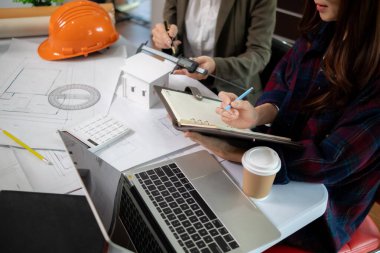 Mimarlar ve mühendisler, inşaatın standartlara uygun ve zamanında tamamlandığından emin olmak için konut inşaatının nasıl tasarlanacağını tartışıyor. Mühendisler ve mimarlardan oluşan bir ekip bina tasarımı ve yapısını tartıştı.