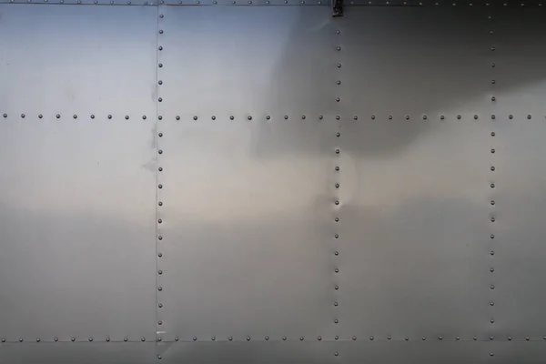 バックグラウンドの金属壁は 住宅用車両として再利用された飛行機の胴体の壁です 金属のリベットが付いている金属の壁は一緒に接合箇所を飛行機の金属の壁およびコピーのスペースです — ストック写真