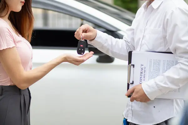 car dealer delivers keys to customer after  customer has selected car they want and agreed to buy the car with the dealer. The concept of entering into a sales contract with a trusted distributor