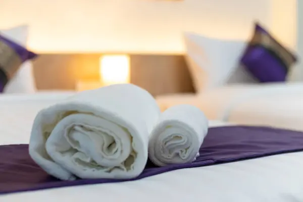 Rolls of white towels are placed on the bed so that hotel guests can easily access them. White towels that the hotel has prepared on the beds for customers who stay. Copy Space for text.