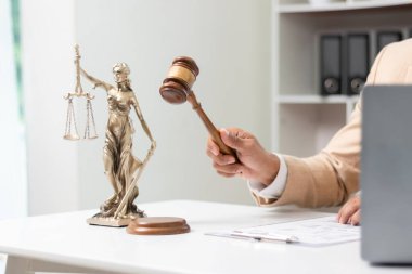 Hâkimin hukuk bürosundaki tokmağı, yargıcın davayla ilgili kararını sembolize etmek için masaya kondu. Hukuki danışmanlık bürosundaki avukatların ahşap masasının üzerindeki tokmak tahtası davalarda adil kararın sembolü olarak..