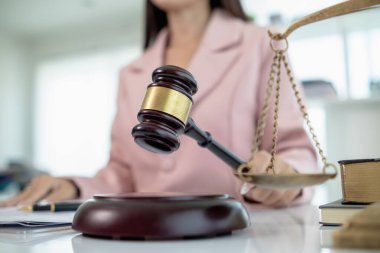 Hâkimin hukuk bürosundaki tokmağı, yargıcın davayla ilgili kararını sembolize etmek için masaya kondu. Hukuki danışmanlık bürosundaki avukatların ahşap masasının üzerindeki tokmak tahtası davalarda adil kararın sembolü olarak..