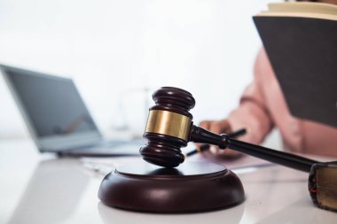 Hâkimin hukuk bürosundaki tokmağı, yargıcın davayla ilgili kararını sembolize etmek için masaya kondu. Hukuki danışmanlık bürosundaki avukatların ahşap masasının üzerindeki tokmak tahtası davalarda adil kararın sembolü olarak..