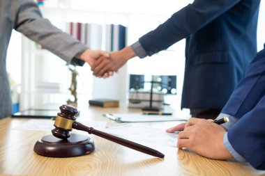 Hâkimin hukuk bürosundaki tokmağı, yargıcın davayla ilgili kararını sembolize etmek için masaya kondu. Hukuki danışmanlık bürosundaki avukatların ahşap masasının üzerindeki tokmak tahtası davalarda adil kararın sembolü olarak..