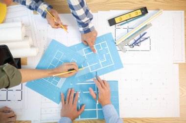 Mimarlar ve inşaat mühendisleri inşaat projesinin tamamlanmasını hesaplamak için yapı planlarını tartışmak üzere bir araya geliyorlar. Emlak inşaat işi konsepti.