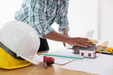 Mimar, inşaat mühendisliği ekibinin çizimlere göre bina inşa etmeden önce gözden geçireceği bina modelini ve inşaat planlarını hazırlıyor..