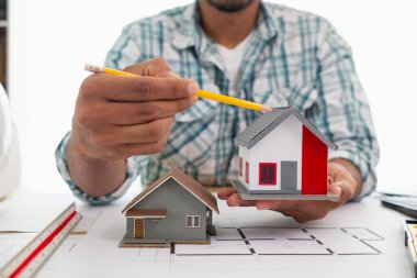 Mimar, inşaat mühendisliği ekibinin çizimlere göre bina inşa etmeden önce gözden geçireceği bina modelini ve inşaat planlarını hazırlıyor..