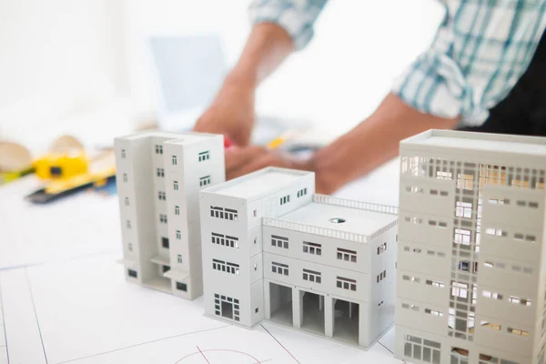 Building models and blueprints are placed on work desks in the construction engineering team offices to plan construction to achieve their goals and to simulate building models for clients to see.