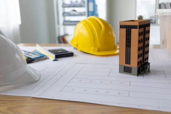 Building models and blueprints are placed on work desks in the construction engineering team offices to plan construction to achieve their goals and to simulate building models for clients to see.