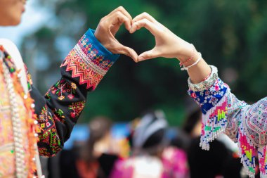 Kadın elini kaldırdı ve sevgi sembolü yaptı. Arkadaşlarına ve sevgililerine karşı dostluk ve nezaket. Kadınlar, sevgi ve dostluk anlamına gelen bir kalp sembolü yapmak için ellerini kullanır..
