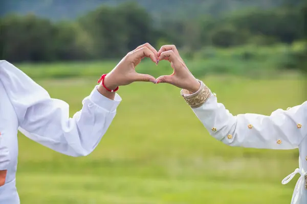 lover raises her hands and makes heart symbol express meaning of love friendship and kindness towards her friend and lover. couple uses their hands to make heart symbol that means love and friendship.