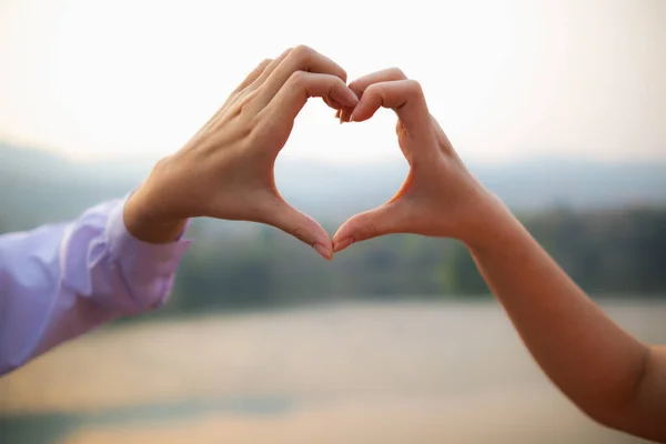 woman raised her hands and made heart symbol to express meaning of love friendship and kindness to her friends and lovers. woman uses her hands to make a heart symbol that means love and friendship.