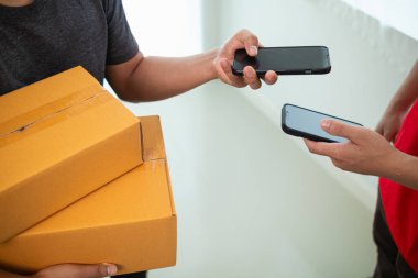 Kadın, dokunaklı parayı azaltmak ve konforu sağlamak için cep telefonu uygulaması yoluyla paketin parasını alıyor ve transfer ediyor. Uygulama yoluyla paketleri ödemek için tarama kavramı