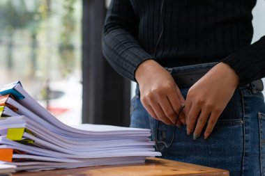 Sekreter, ofis masasındaki bir yığın önemli belgeyi inceliyor. Toplantıya zamanında sunum için müdüre teslim ediyor. Belge yığınlarından bilgi bulmada zorluk kavramı