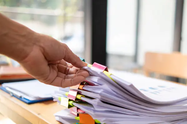 A young secretary receives a pile of documents to find important information for the company manager to use in a meeting. The concept of finding important documents from piles of overlapping documents
