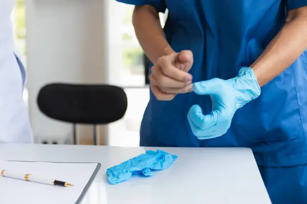 stock image doctor is wearing blue rubber gloves prevent direct contact with patient because virus may be traced to patient body and medical rubber gloves also help prevent virus from being transmitted to patient