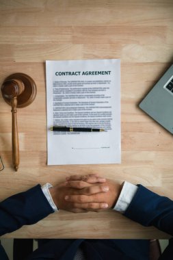contract was placed on table inside legal counsel's office, ready for investors to sign the contract to hire a team of lawyers to provide legal advice for their investment. legal consulting concept clipart