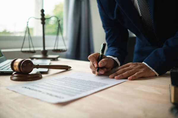 contract was placed on table inside legal counsel's office, ready for investors to sign the contract to hire a team of lawyers to provide legal advice for their investment. legal consulting concept