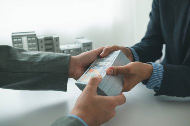 Emlak komisyoncuları, yüksek binaların yasak olduğu bölgelerde hükümet yetkililerine para sorunlu inşaat izinleri vererek rüşvet veriyorlar. İşi kolaylaştırmak için devlet memurlarına rüşvet vermek