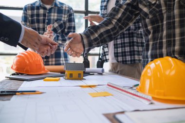 Mimarlar ve tasarımcılar inşaat için mühendislik ekibine ve ustabaşına teslim edilmeden önce inşaat planlarından bahsediyorlar. Mimarlar ve tasarımcılardan oluşan bir takımdan denetim konsepti planları