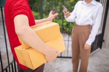KOBİ işletme operatörü, uygulama çevrimiçi alışverişi ile çevrimiçi pazarlamaya katıldıktan sonra ürünleri almaya gelecek olan teslimat şirketi için ürünleri paket kutusuna koyup teftiş ediyor.
