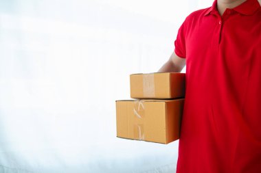 KOBİ işletme operatörü, uygulama çevrimiçi alışverişi ile çevrimiçi pazarlamaya katıldıktan sonra ürünleri almaya gelecek olan teslimat şirketi için ürünleri paket kutusuna koyup teftiş ediyor.