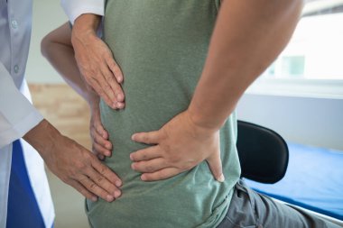 Adam çok çalıştığı ve kas iltihabına yol açtığı için omzunun arkasındaki kas ağrısının tedavisi için hastaneye yatırılmış. Doktor sırtındaki ve omuzlarındaki kas ağrılarını tedavi ediyor..