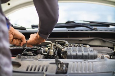 Araç hizmet merkezi tamircileri araba ve motoru kontrol ediyor. Kullanıma hazır ve merkezin garantisine göre mükemmel durumda olduklarından emin olun. Güvenli sürüş için periyodik araç denetimleri.