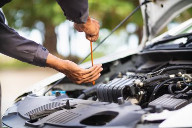 Araç hizmet merkezi tamircileri araba ve motoru kontrol ediyor. Kullanıma hazır ve merkezin garantisine göre mükemmel durumda olduklarından emin olun. Güvenli sürüş için periyodik araç denetimleri.