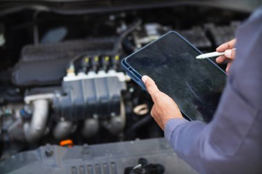 Araç hizmet merkezi tamircileri araba ve motoru kontrol ediyor. Kullanıma hazır ve merkezin garantisine göre mükemmel durumda olduklarından emin olun. Güvenli sürüş için periyodik araç denetimleri.